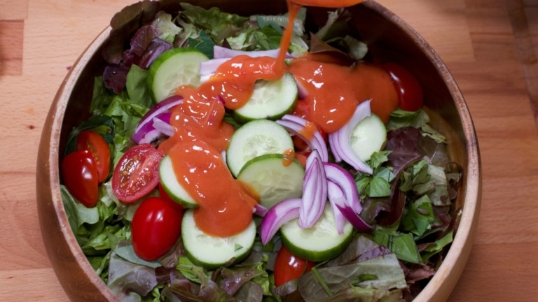 Bowl of green salad with French dressing
