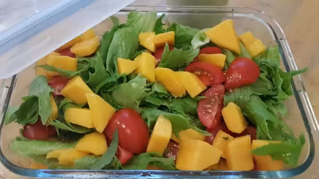Bol en verre avec salade de mangue et tomate