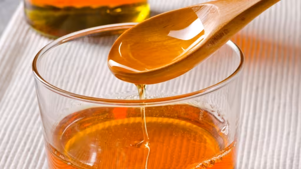 Glas mit Agavendicksaft und Löffel