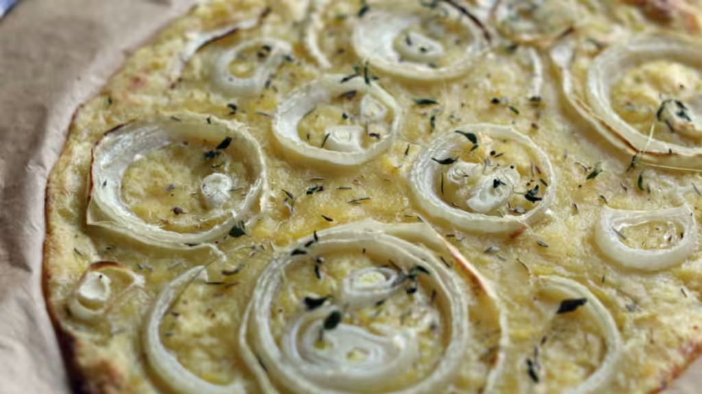 Potato and onion flatbread on baking paper